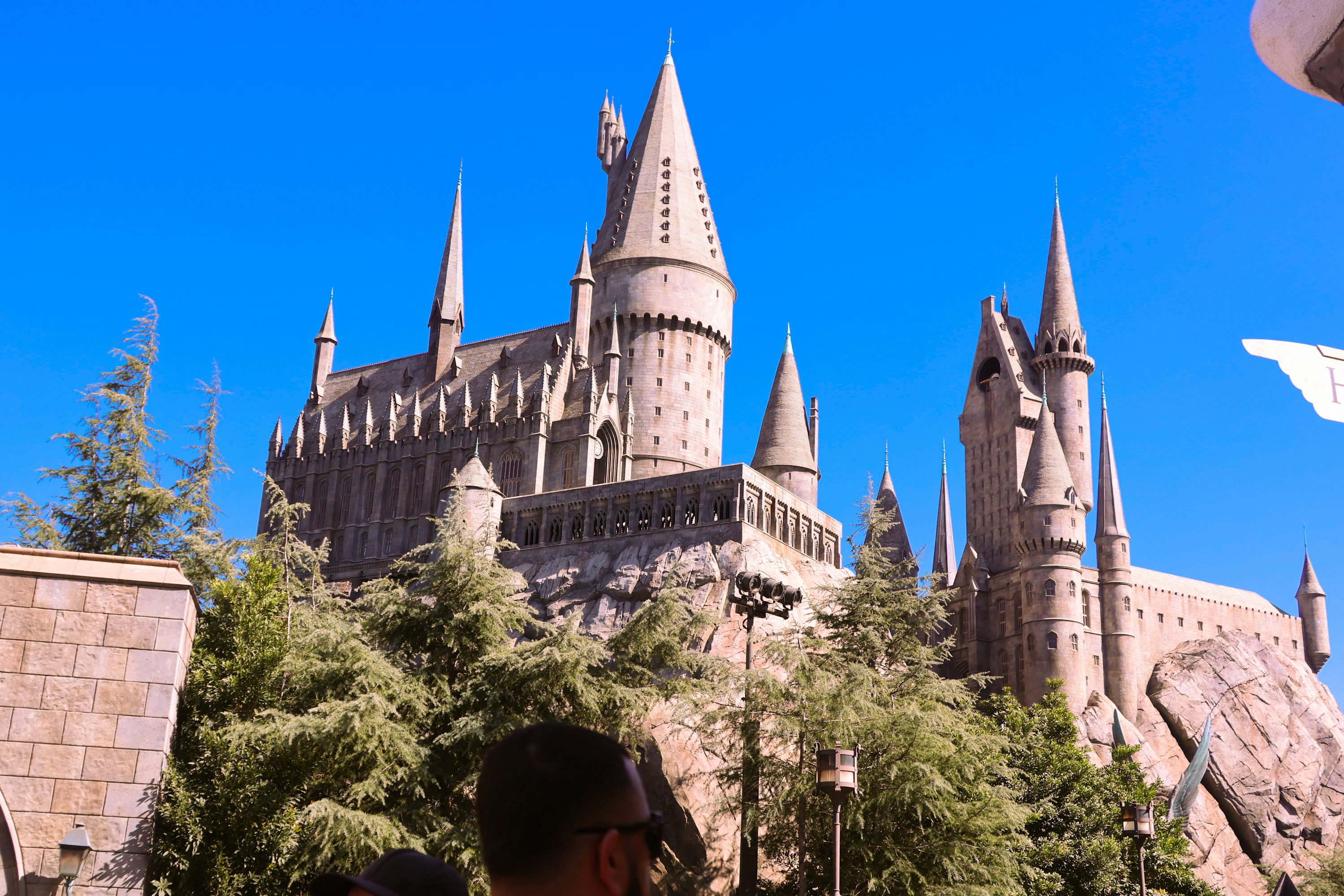 The Hogwarts-themed castle attraction above rockwork and trees at Universal Studios Hollywood.